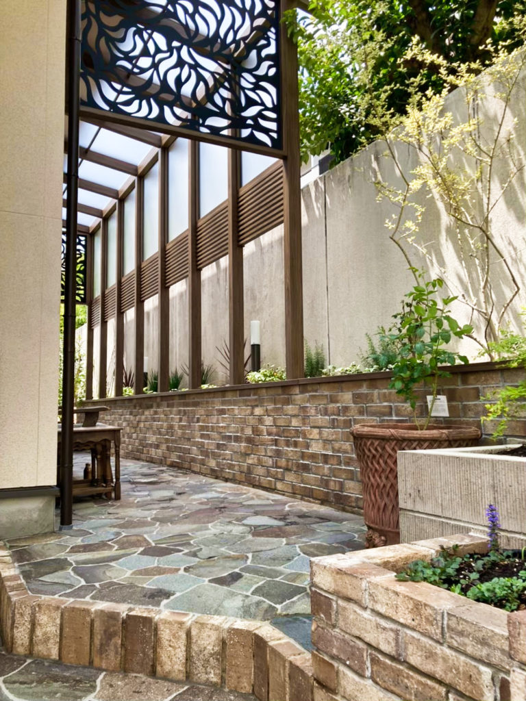 jardin-pente-table-ronde-bois-chaises-blanc-neige-sol-bois